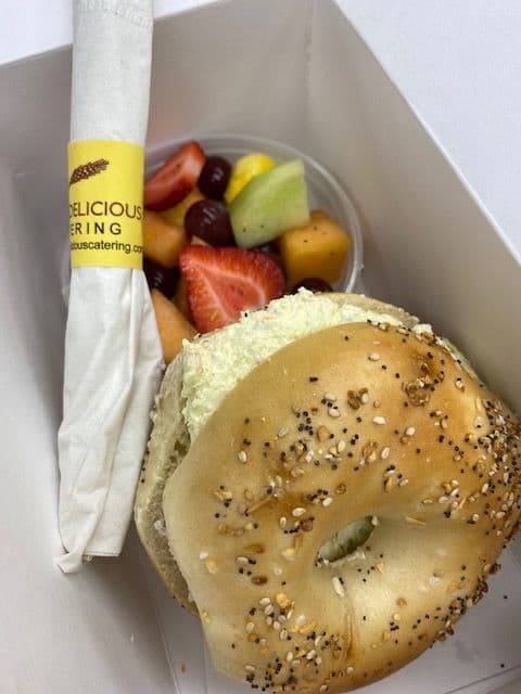 Individually boxed bagel with cream cheese and fruit salad for a corporate breakfast