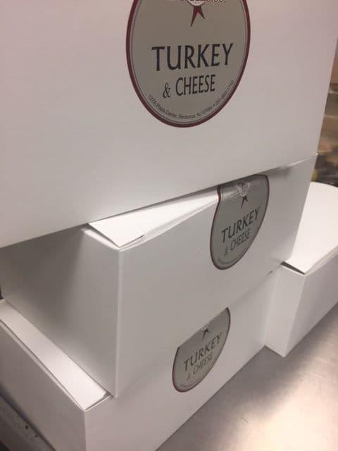 Stack of boxed lunches labeled Turkey & Cheese for an office meeting